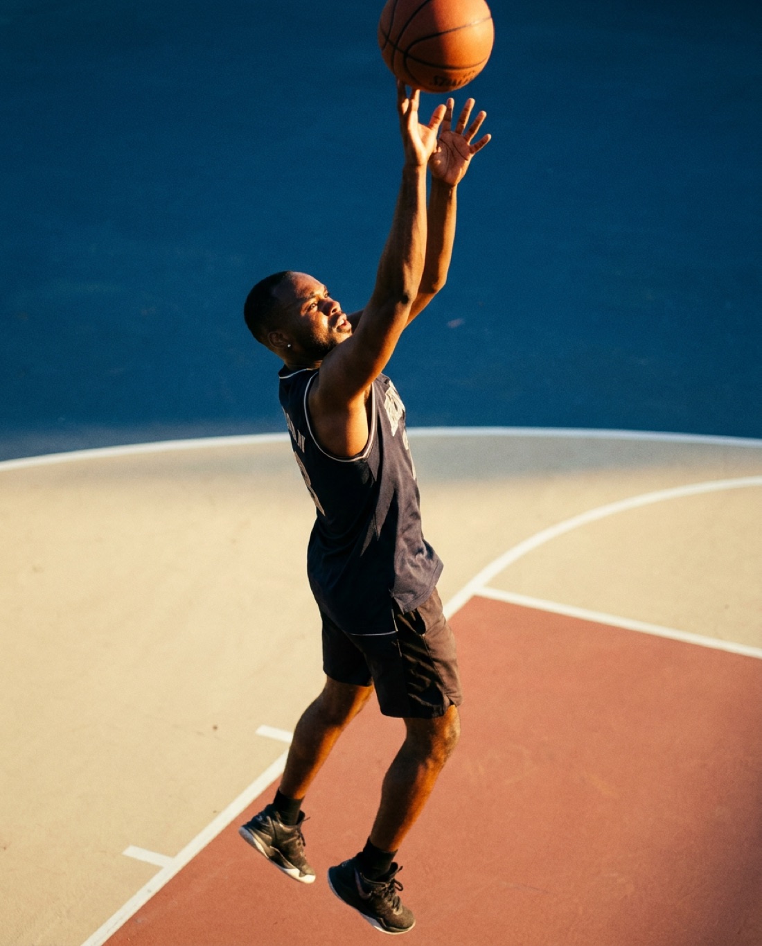 Gozzy Nwogbo rising for a layup on an outdoor court